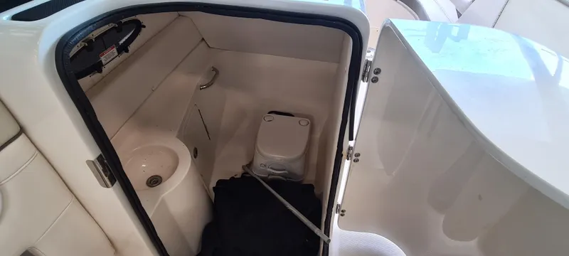 Slide: The Image of 2012 Sea Ray 260 Sundeck interior with compact marine toilet and sink. - 15