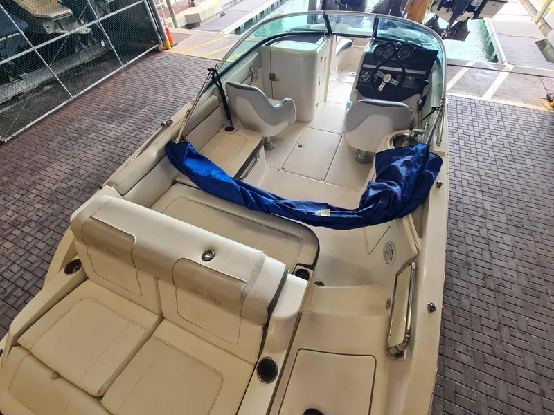 Slide: The Image of 2012 Sea Ray 260 Sundeck boat interior with seating and dashboard, docked in a marina. - 21