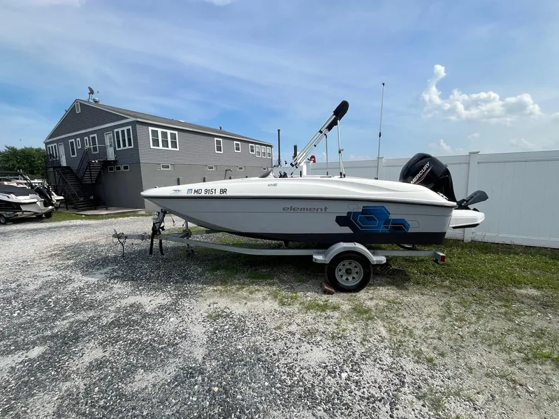 The Image of 2021 Bayliner Element E16 boat on trailer, parked near a building under a clear sky. - 0