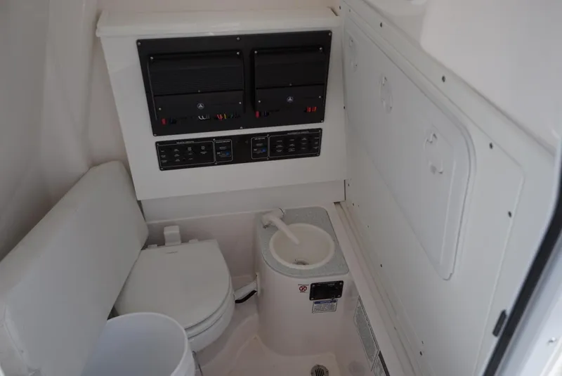 Slide: The Image of Interior of 2025 Sea Fox 282 Hybrid LT boat featuring a compact marine toilet. - 27