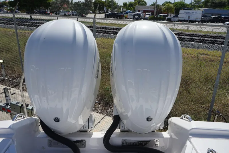 Slide: The Image of Twin outboard engines on a 2025 Sea Fox 282 Hybrid LT boat, parked near a fence. - 38