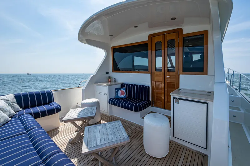 Slide: The Image of 2017 Grand Banks 44 Eastbay SX yacht deck with seating, table, and ocean view. - 12