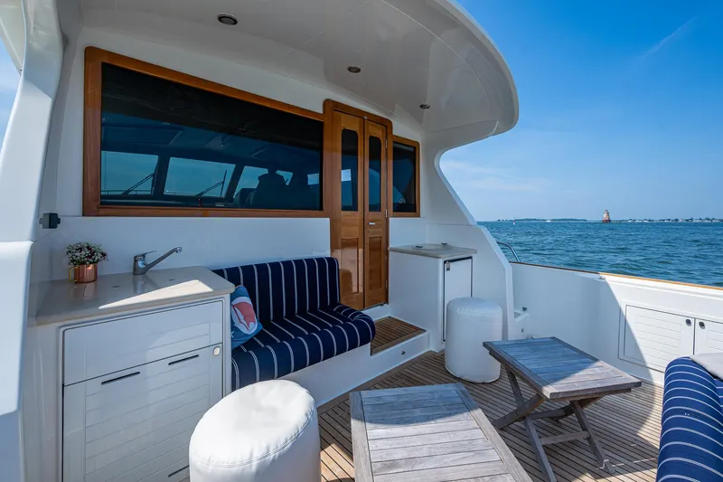 Slide: The Image of Luxurious 2017 Grand Banks 44 Eastbay SX yacht deck with striped seating and ocean view. - 13