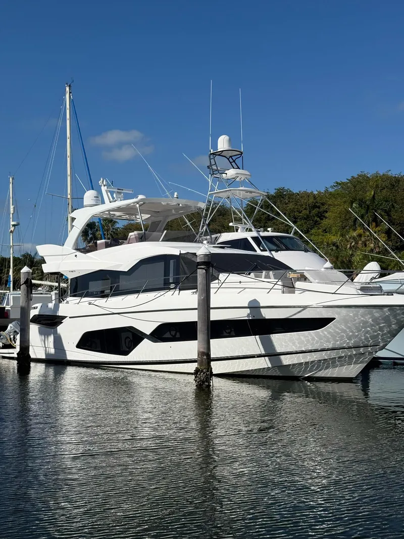 The Image of 2022 Sunseeker Manhattan 68 yacht docked in a marina under clear blue skies. - 0