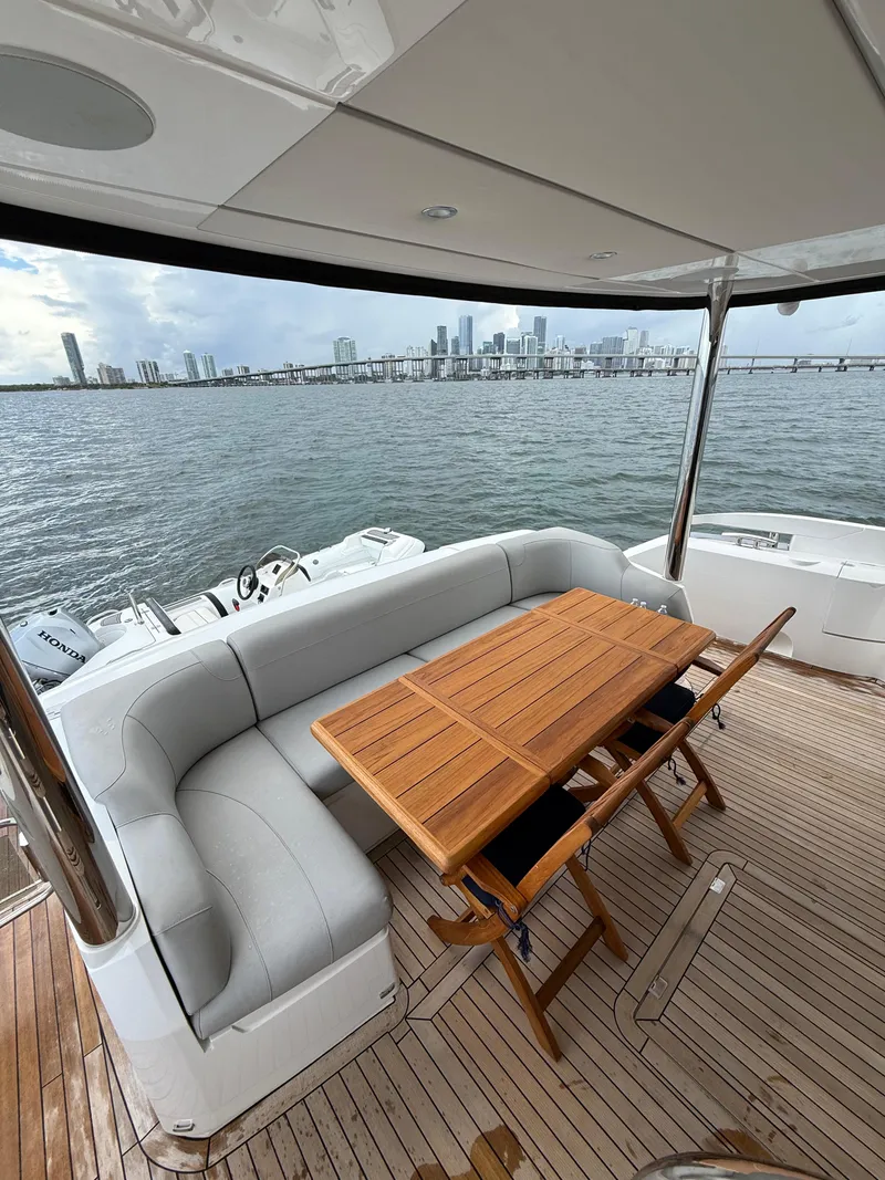 Slide: The Image of Luxurious Sunseeker Manhattan 68 yacht deck with seating, table, and city skyline view. - 12