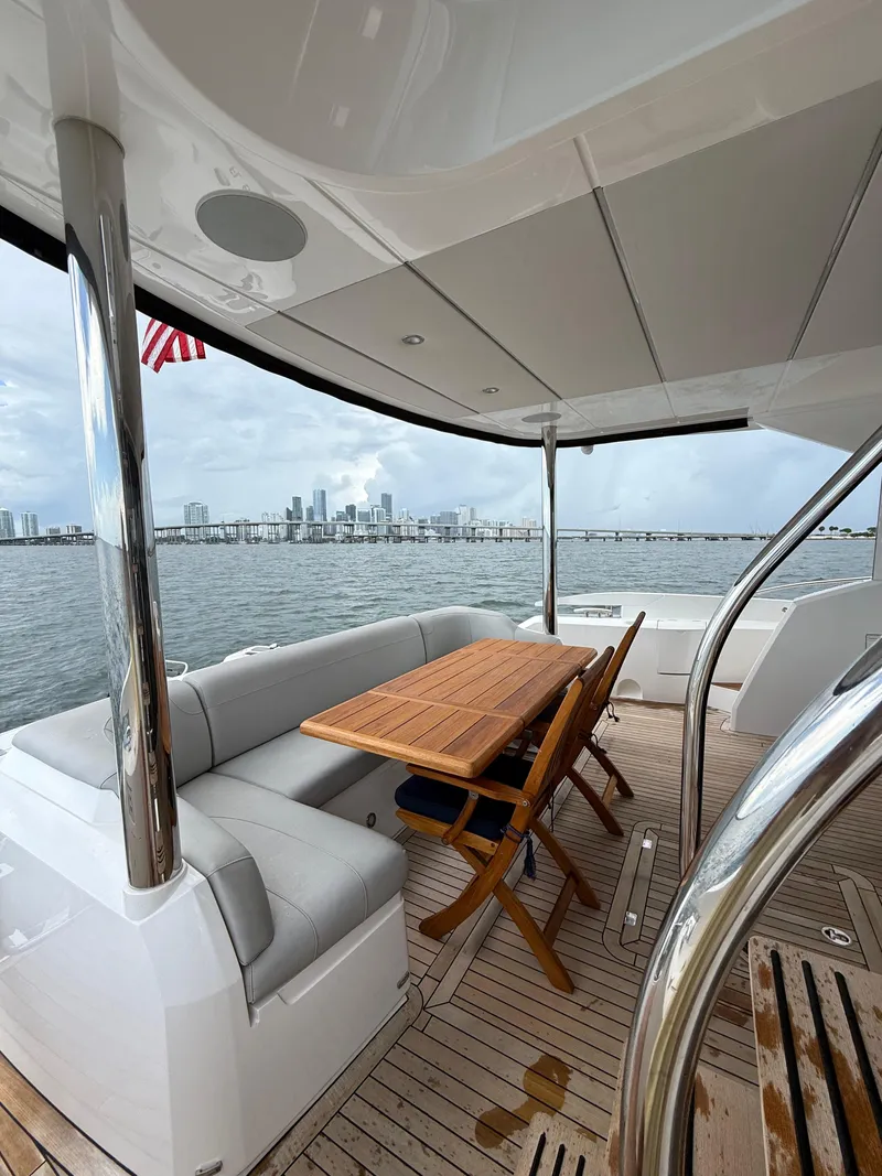 Slide: The Image of Luxurious Sunseeker Manhattan 68 yacht deck with seating, table, and city skyline view. - 13