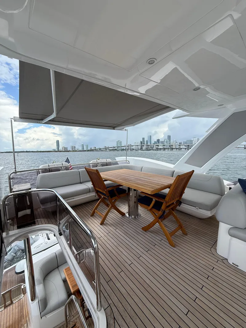 Slide: The Image of Luxurious Sunseeker Manhattan 68 yacht deck with seating, table, and city skyline view. - 15