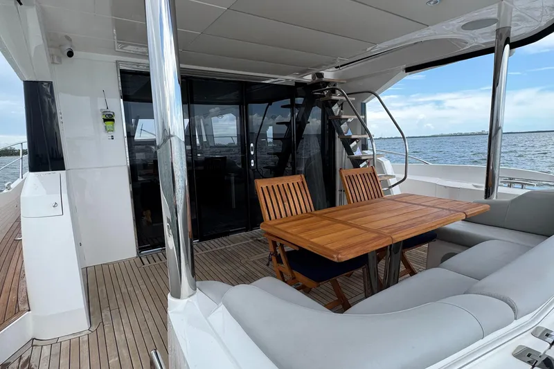 Slide: The Image of Luxurious Sunseeker Manhattan 68 yacht deck with wooden table and seating, 2022 model. - 17