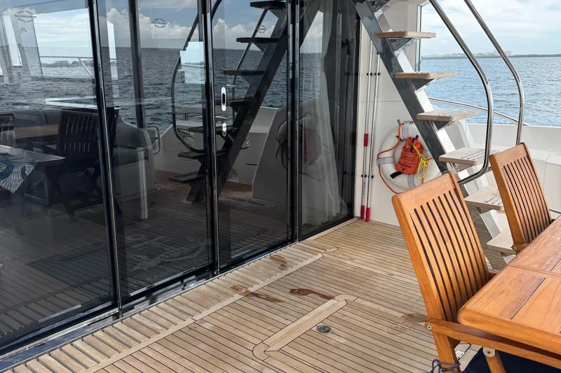 Slide: The Image of Sunseeker Manhattan 68 yacht deck with wooden furniture and ocean view, 2022 model. - 19