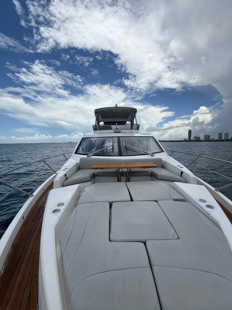 Slide: The Image of 2022 Sunseeker Manhattan 68 yacht with spacious deck, ocean view, and cloudy sky. - 3