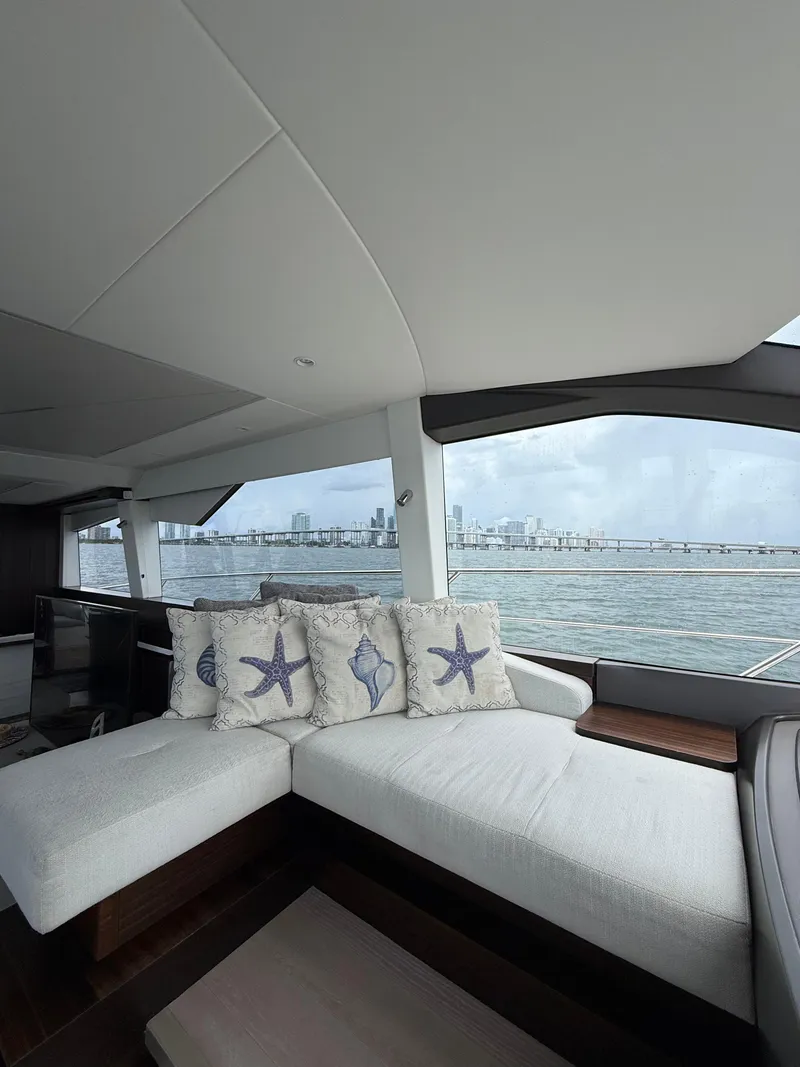 Slide: The Image of Luxurious Sunseeker Manhattan 68 yacht interior with ocean view, featuring elegant seating and decorative pillows. - 46