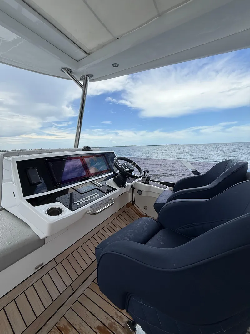 Slide: The Image of Helm of 2022 Sunseeker Manhattan 68 yacht with ocean view and modern controls. - 48