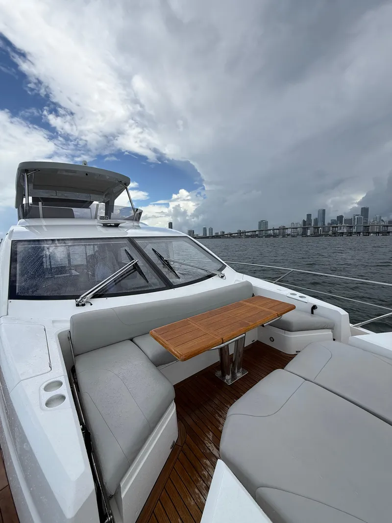Slide: The Image of 2022 Sunseeker Manhattan 68 yacht with seating area, ocean view, and city skyline. - 6