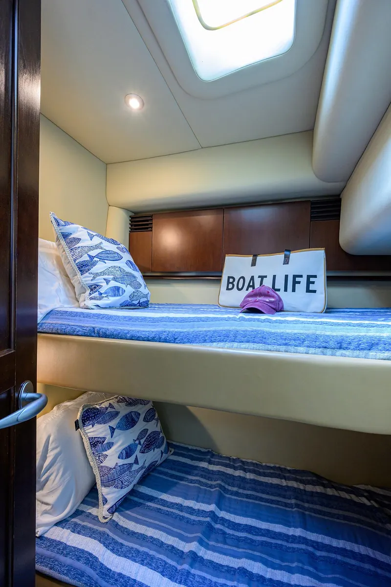 Slide: The Image of 2005 Sea Ray 52 Sedan Bridge cabin with bunk beds, nautical decor, and "Boat Life" pillow. - 15