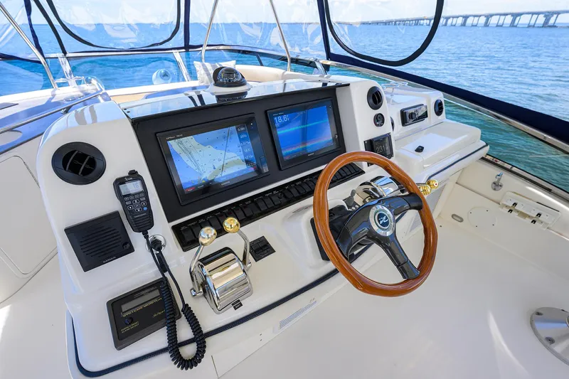Slide: The Image of Helm of 2005 Sea Ray 52 Sedan Bridge with navigation screens and wooden steering wheel. - 19