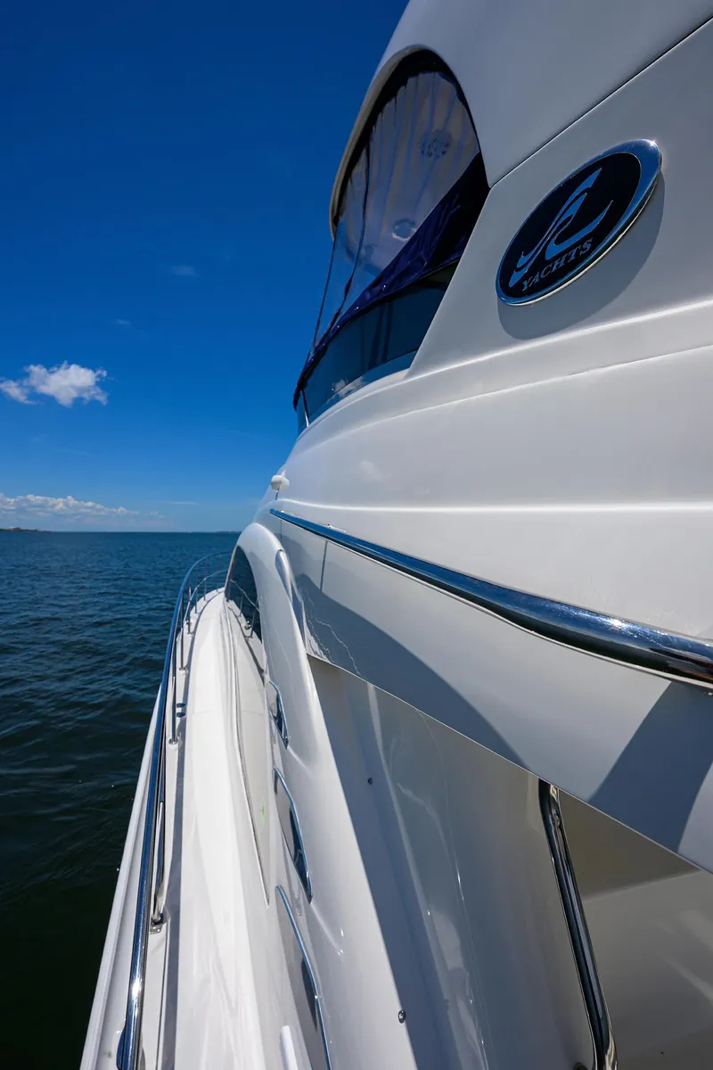 Slide: The Image of 2005 Sea Ray 52 Sedan Bridge yacht cruising on open water under clear blue sky. - 23