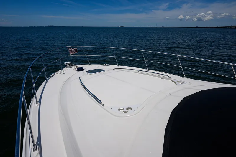 Slide: The Image of 2005 Sea Ray 52 Sedan Bridge yacht cruising on open water under clear skies. - 24