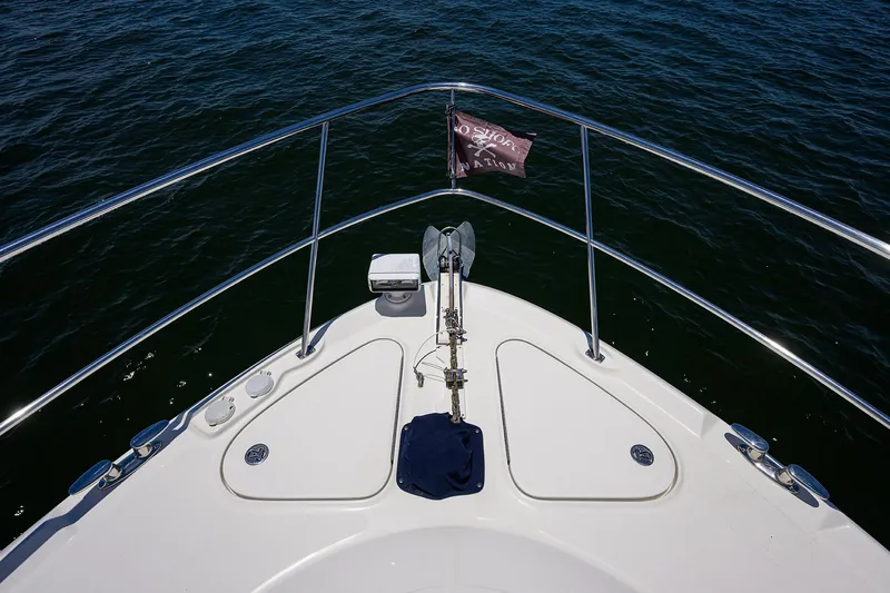 Slide: The Image of Bow of 2005 Sea Ray 52 Sedan Bridge yacht on water, featuring anchor and railing. - 25
