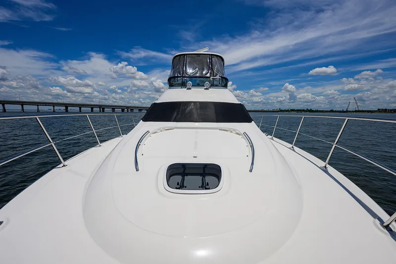 Slide: The Image of 2005 Sea Ray 52 Sedan Bridge yacht on open water under blue sky. - 26