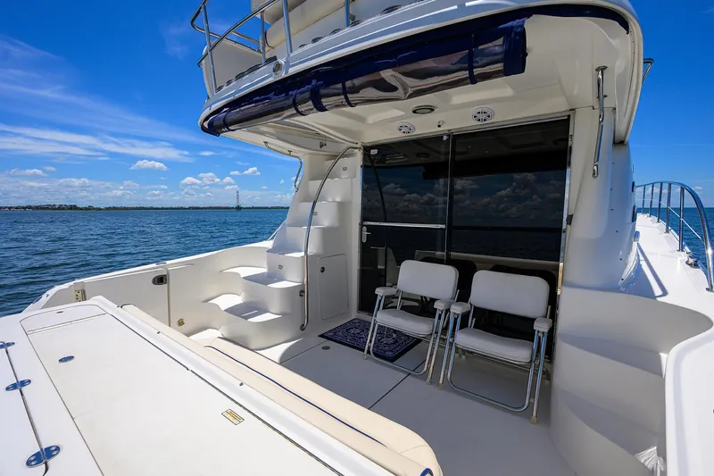 Slide: The Image of 2005 Sea Ray 52 Sedan Bridge yacht deck with chairs, overlooking calm blue waters. - 29