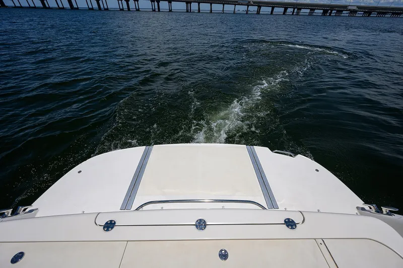 Slide: The Image of 2005 Sea Ray 52 Sedan Bridge cruising on open water near a bridge. - 33