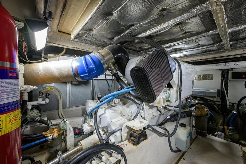 Slide: The Image of Engine room of 2005 Sea Ray 52 Sedan Bridge yacht, featuring mechanical components and fire extinguisher. - 36