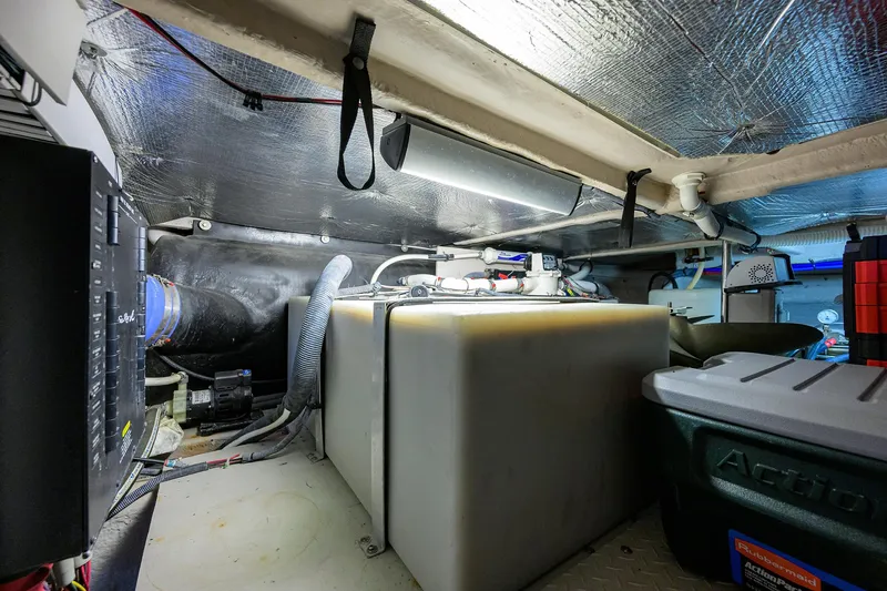 Slide: The Image of Engine room of a 2005 Sea Ray 52 Sedan Bridge, featuring storage and mechanical components. - 39