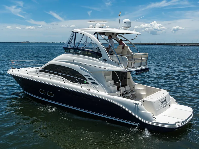 Slide: The Image of 2005 Sea Ray 52 Sedan Bridge yacht cruising on open water under a clear sky. - 42
