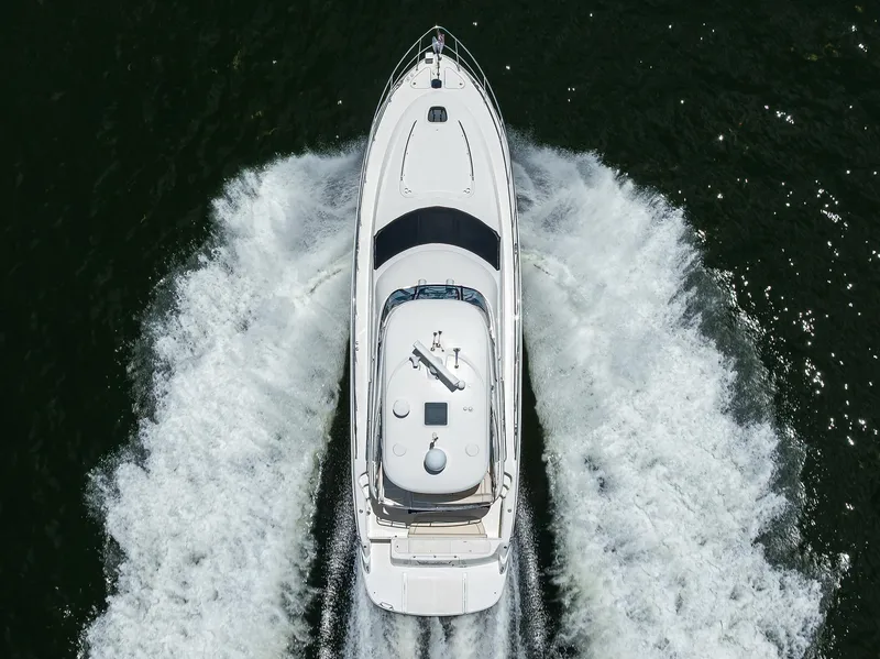 Slide: The Image of 2005 Sea Ray 52 Sedan Bridge yacht cruising on open water, aerial view. - 43