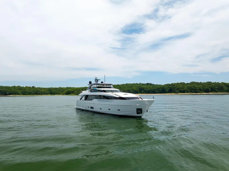 Slide: The Image of 2024 Sanlorenzo SL90A yacht cruising on calm waters near a lush shoreline. - 12