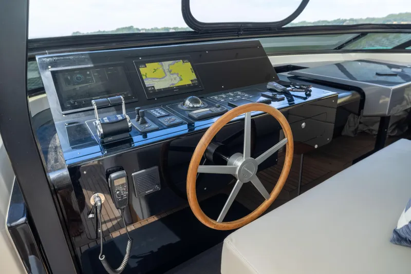 Slide: The Image of 2024 Sanlorenzo SL90A yacht helm with advanced navigation controls and wooden steering wheel. - 27