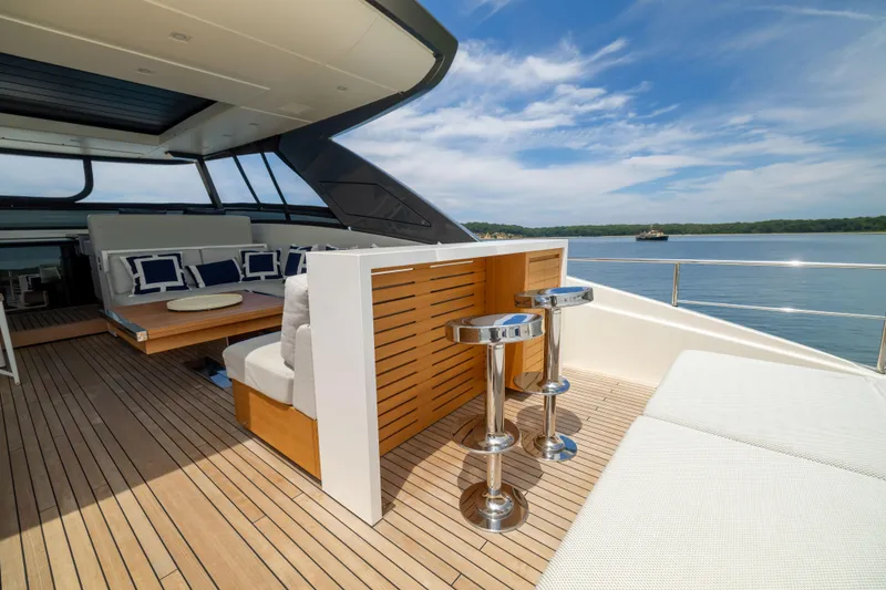 Slide: The Image of Luxurious 2024 Sanlorenzo SL90A yacht deck with seating and bar stools, overlooking serene waters. - 35