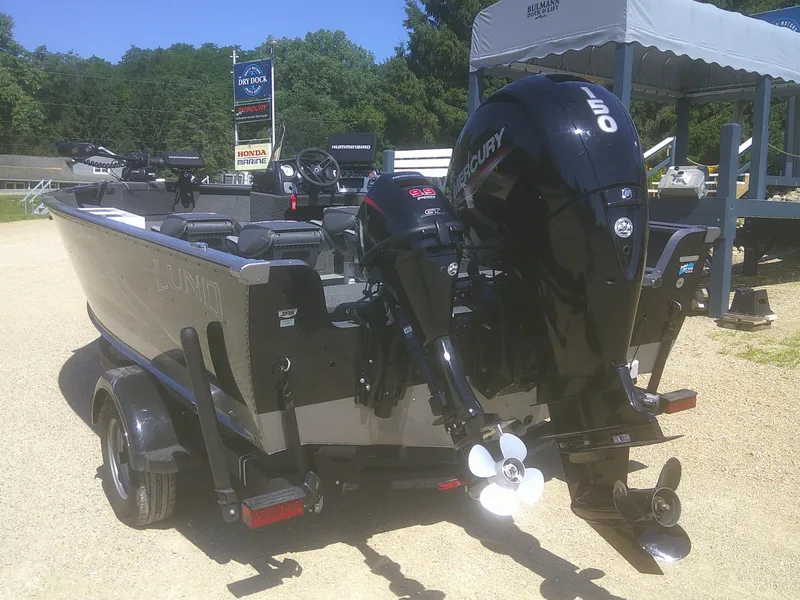 Slide: The Image of 2020 Lund 1875 Impact SS boat with Mercury outboard motor, parked on a trailer. - 3