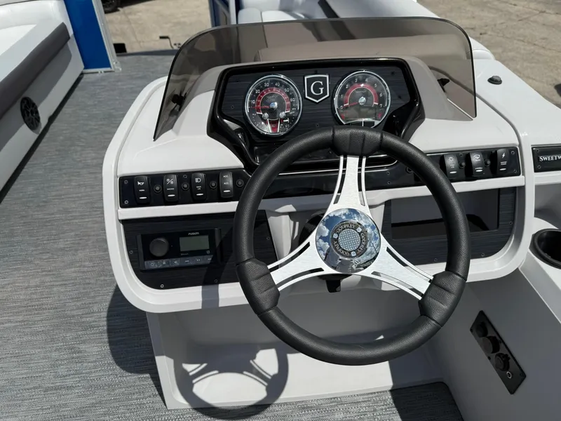 Slide: The Image of 2024 Godfrey SWEETWATER 2286 SB boat dashboard with steering wheel and control panel. - 6