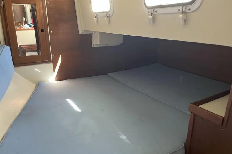 Slide: The Image of Interior cabin of a 1989 Catalina 34 MkII sailboat with blue cushions and wooden accents. - 18