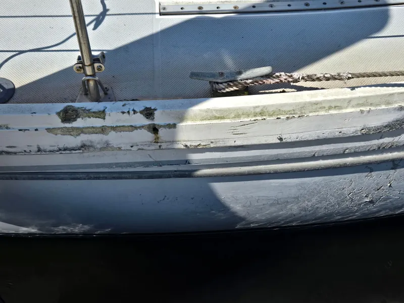 Slide: The Image of 1989 Catalina 34 MkII sailboat with weathered hull and visible wear. - 19