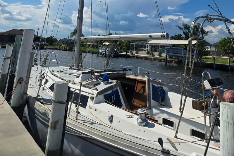Slide: The Image of 1989 Catalina 34 MkII sailboat docked at a marina under a cloudy sky. - 3
