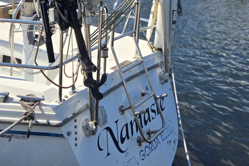 Slide: The Image of 1989 Catalina 34 MkII sailboat stern with ladder, docked on calm water. - 4