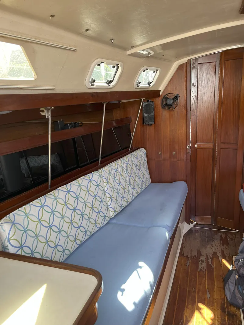 Slide: The Image of Interior of 1989 Catalina 34 MkII sailboat with blue cushioned seating and wooden paneling. - 8