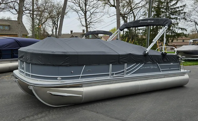 Slide: The Image of 2023 South Bay S224 UL TRIPLE pontoon boat with cover in a parking lot. - 22