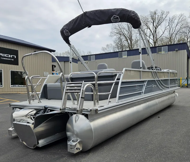 Slide: The Image of 2023 South Bay S224 UL TRIPLE pontoon boat with canopy, docked outdoors. - 4
