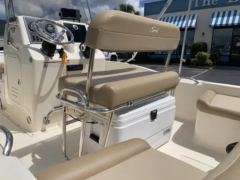 Slide: The Image of 2019 Scout 175 Sportfish boat interior with beige seating and steering console. - 11