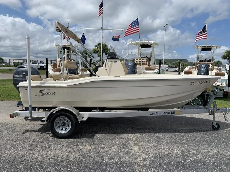 Slide: The Image of 2019 Scout 175 Sportfish boat on trailer, flags in background, outdoor display. - 5