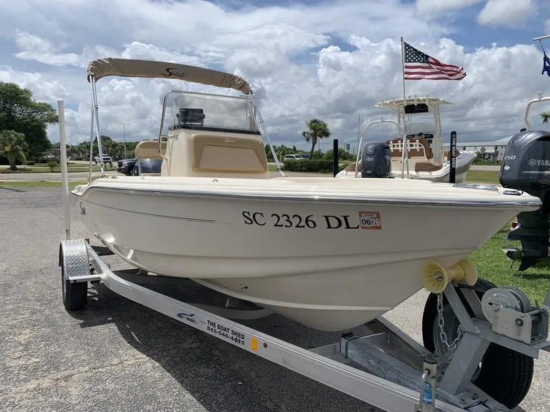 Slide: The Image of 2019 Scout 175 Sportfish boat on trailer, parked outdoors under cloudy sky. - 6