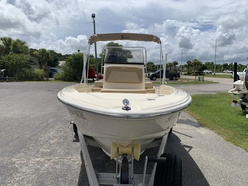 Slide: The Image of 2019 Scout 175 Sportfish boat on trailer, parked outdoors under cloudy sky. - 7