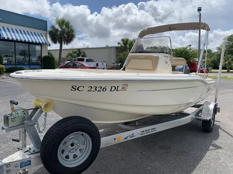 Slide: The Image of 2019 Scout 175 Sportfish boat on trailer, parked outdoors under cloudy sky. - 8