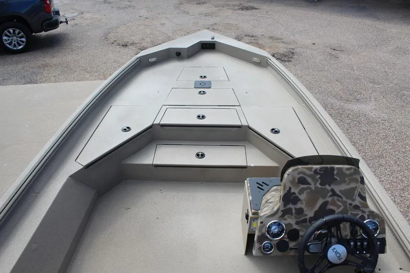 Slide: The Image of 2026 Excel Bolt 183 boat interior with storage compartments and camo-patterned steering console. - 14