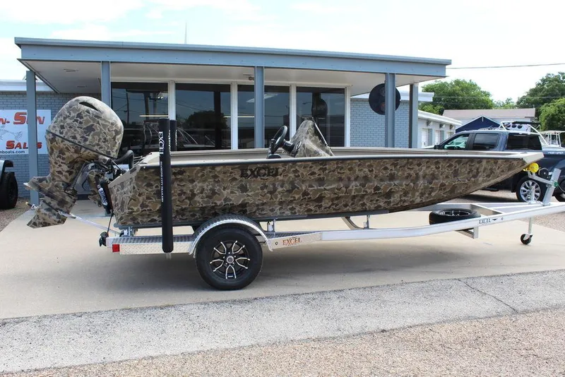 Slide: The Image of 2026 Excel Bolt 183 boat with camouflage design on a trailer outside a dealership. - 2