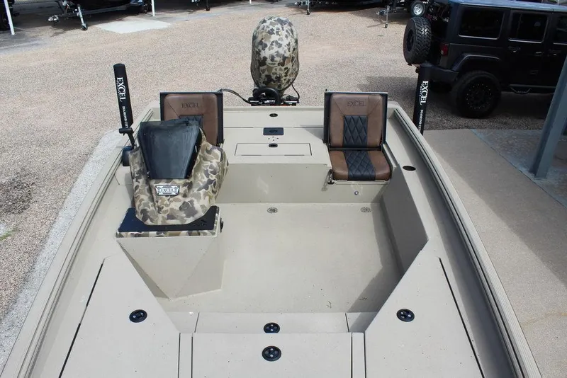 Slide: The Image of 2026 Excel Bolt 183 boat interior with camo and leather seats, parked outdoors. - 6