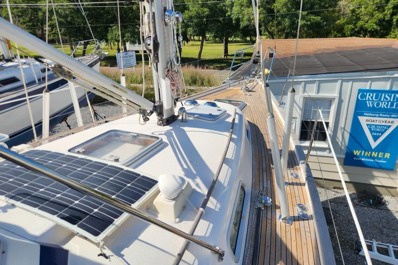 Slide: The Image of 2007 Hallberg-Rassy 37 sailboat deck with solar panels, docked near award sign. - 13